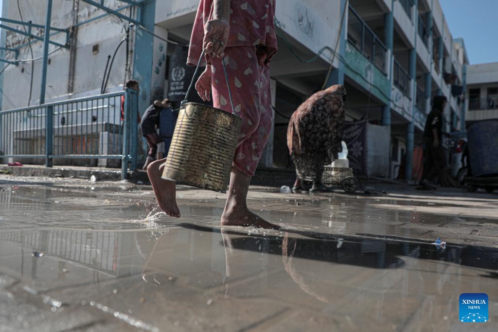 People fetch water at a shelter affiliated with the United Nations Relief and Works Agency for Palestine Refugees in the Near East (UNRWA) in the southern Gaza Strip city of Khan Younis, on Oct. 29, 2024. UN Secretary-General Antonio Guterres on Tuesday sent a letter to Israeli Prime Minister Benjamin Netanyahu, expressing his concerns over the new legislations that banned a UN agency's operations, a UN spokesperson said. (Photo: Xinhua)