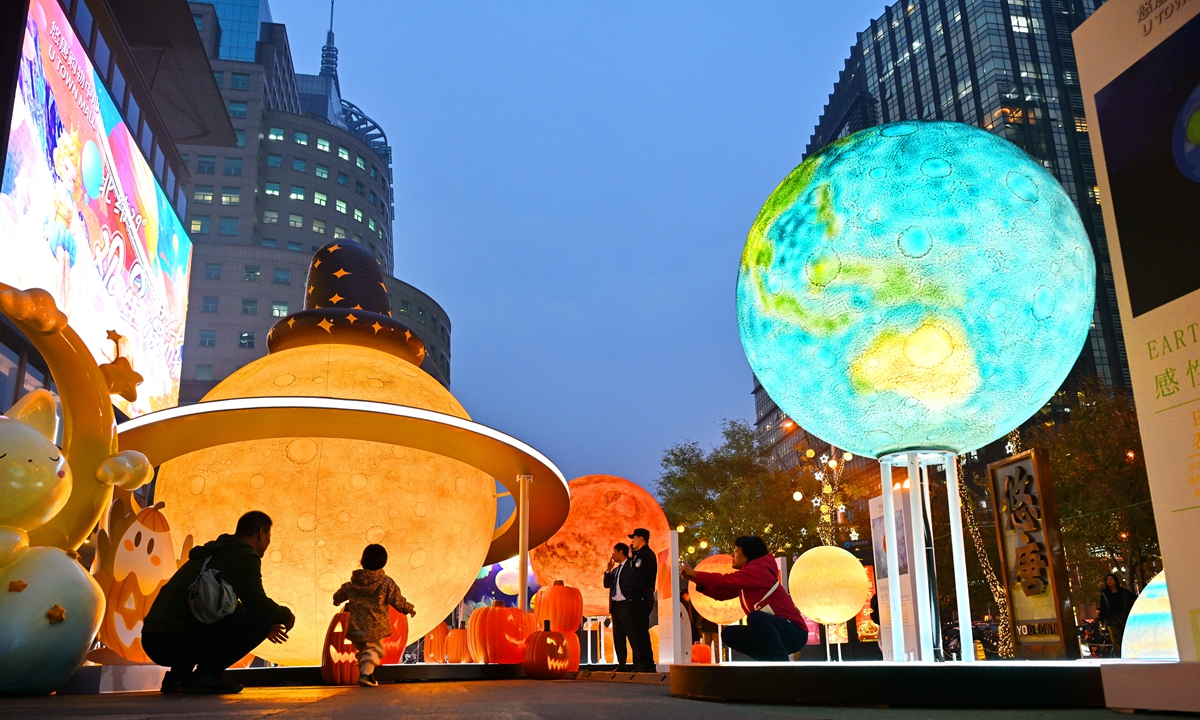 Tourists enjoy themselves at the Beijing Chaoyang International Lighting Festival on October 31, 2024 in Beijing. 