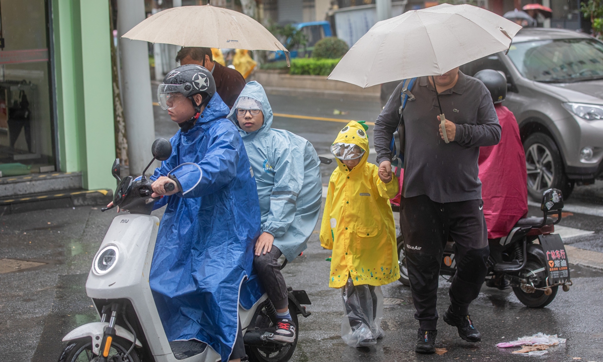 Parents send children to school on November 1, 2024, as Shanghai is expected to experience accumulated rainfall reaching torrential levels due to the impact of typhoon Kong-rey. Photo: VCG