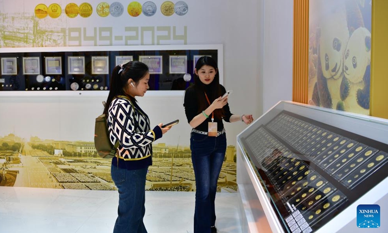 A visitor watches commemorative coins themed on pandas during the Beijing International Coin Exposition 2024 at the China National Convention Center in Beijing, capital of China, Nov. 1, 2024. (Photo: Xinhua)