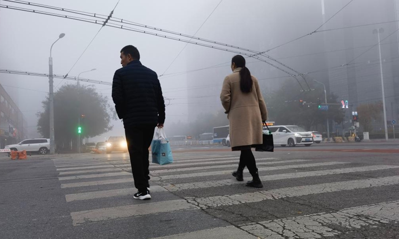 People walk on a street amid fog in Beijing, capital of China, Nov. 2, 2024. (Photo: Xinhua)