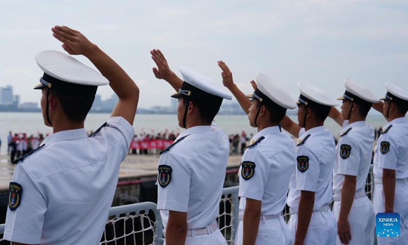 Cadets from the Naval University of Engineering wave to local people on the flight deck of the Chinese navy vessel Qijiguang in Penang, Malaysia, Oct. 8, 2024. (Photo: Xinhua)