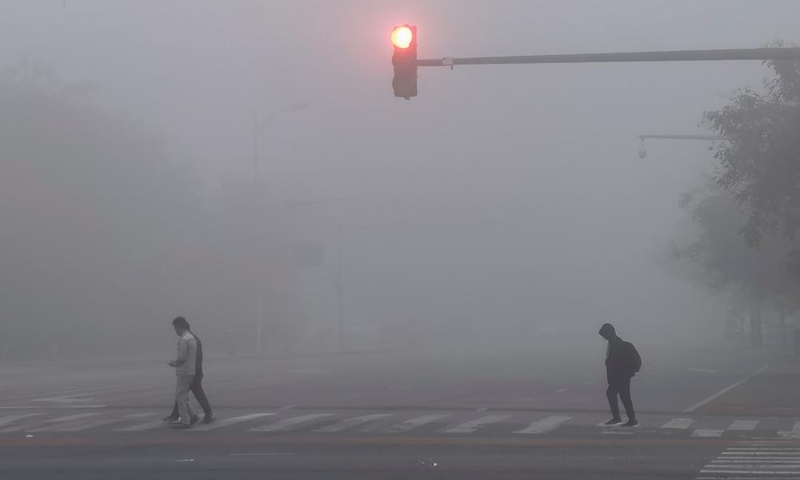 People walk on a street amid fog in Beijing, capital of China, Nov. 2, 2024. (Photo: Xinhua)