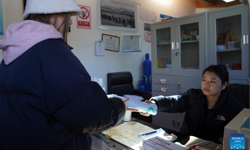 A staff member (R) provides an oxygen cylinder to a tourist at a medical service station at Yading scenic spot in Daocheng County of Tibetan Autonomous Prefecture of Garze, southwest China's Sichuan Province, Oct. 31, 2024. (Photo: Xinhua)