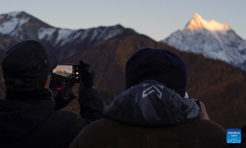 Tourists take photos during sunset at the Yading scenic spot in Daocheng County of Tibetan Autonomous Prefecture of Garze, southwest China's Sichuan Province, Oct. 31, 2024. (Photo: Xinhua)