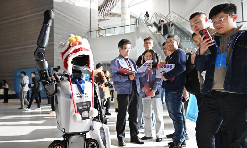 Participants look at a robot at the exhibition area of the 2024 China Automation Congress in Qingdao, east China's Shandong Province, Nov. 2, 2024. The 2024 China Automation Congress, which focuses on the deep integration of automation and artificial intelligence as well as explores the innovative development of new industries and technologies, would last from Nov. 1 to Nov. 3 here. (Photo: Xinhua)