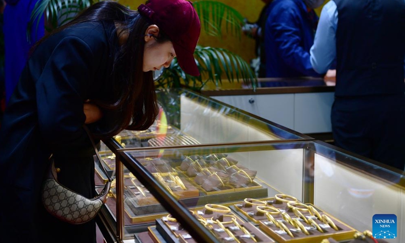 Visitors select gold jewelry during the Beijing International Coin Exposition 2024 at the China National Convention Center in Beijing, capital of China, Nov. 1, 2024. (Photo: Xinhua)