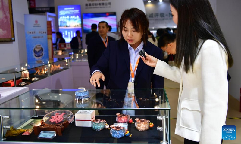 A staff member introduces creative cultural products during the Beijing International Coin Exposition 2024 at the China National Convention Center in Beijing, capital of China, Nov. 1, 2024. (Photo: Xinhua)