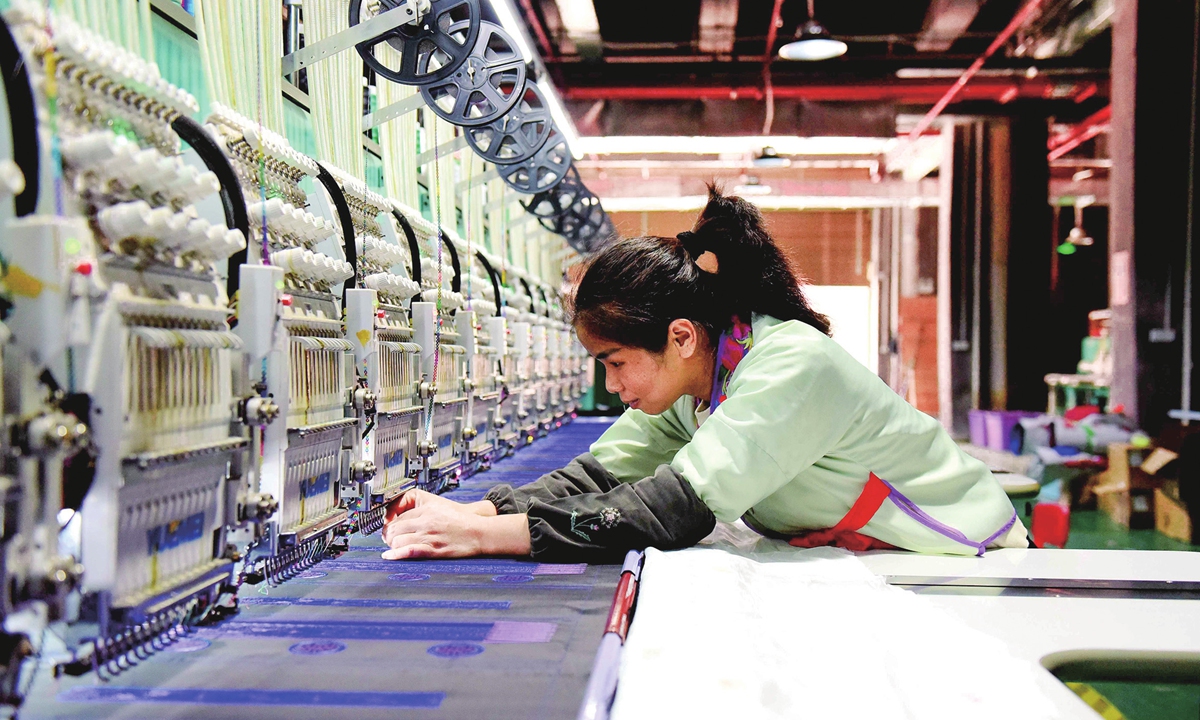 A worker makes embroidered products at a workshop in Congjiang county, Southwest China's Guizhou Province on November 3, 2024. With 