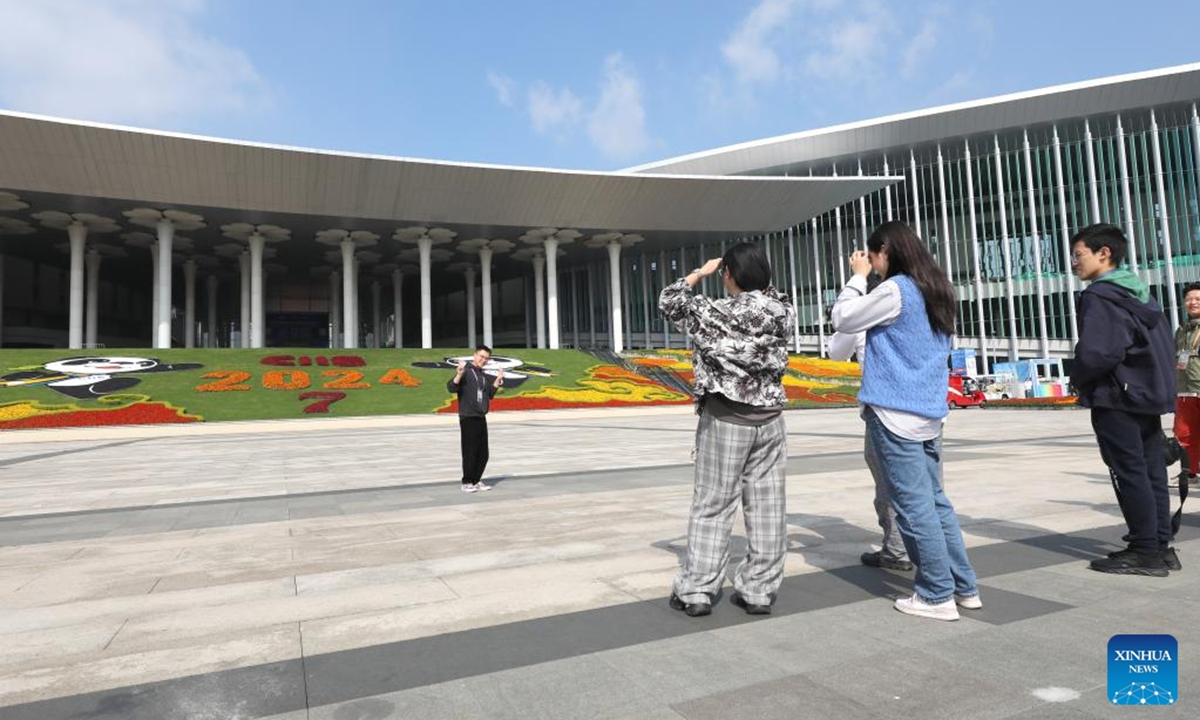 An exhibitor poses for photos at the south square of the National Exhibition and Convention Center (Shanghai), the main venue for the 7th China International Import Expo (CIIE), in east China's Shanghai, Nov. 2, 2024. Preparations for the 7th CIIE, which is scheduled to take place in Shanghai from Nov. 5 to 10, have entered the final stage. (Photo:Xinhua)