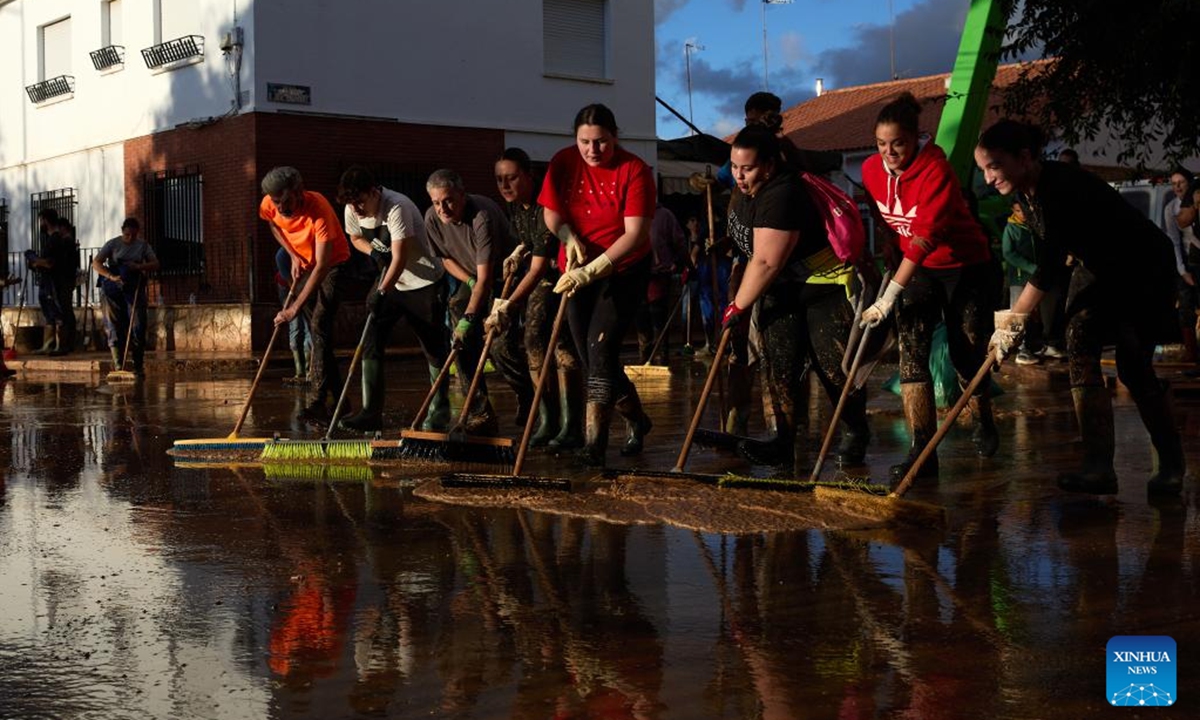 People clear a road after flood in Utiel, Spain, Nov. 2, 2024. Torrential rains over recent days have triggered Spain's worst flooding in decades. The death toll from the flooding had risen to 211 as of Saturday morning, according to the government.   (Photo: Xinhua)