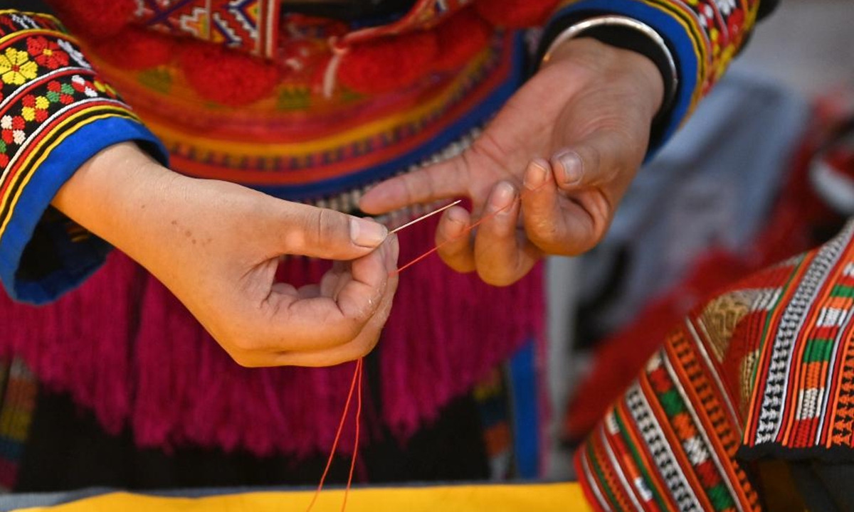 Pan Haiyan threads a needle in her embroidery workshop in Tianlin County, Baise City, south China's Guangxi Zhuang Autonomous Region, Oct. 31, 2024. (Photo: Xinhua)