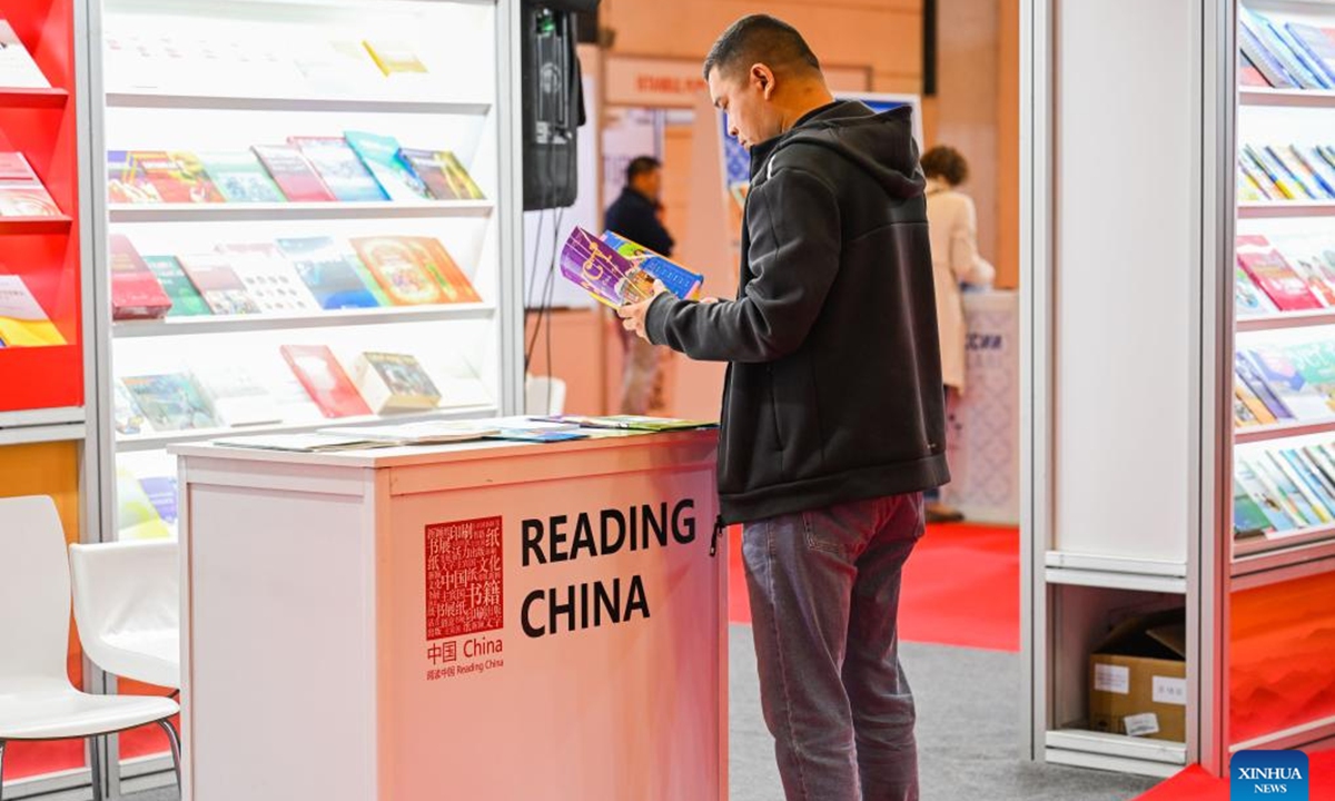 A visitor reads a book at the 41st International Istanbul Book Fair in Istanbul, Türkiye, on Nov. 2, 2024. The Book Fair kicked off here on Saturday, featuring participation from Chinese publishers and a diverse selection of Chinese books. Running until Nov. 10, the fair hosts 12 Chinese publishers this year, who are expected to sign copyright agreements to foster cooperation with participants, according to the fair's website.  (Photo: Xinhua)