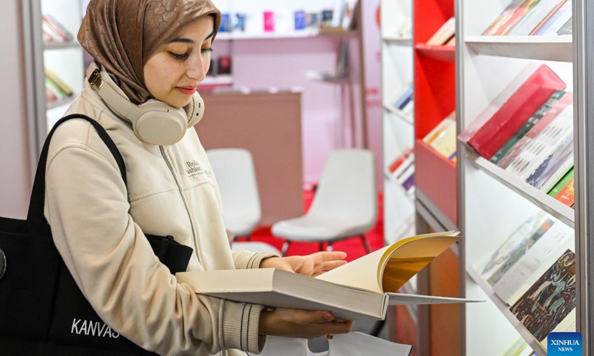 A visitor reads a book at the 41st International Istanbul Book Fair in Istanbul, Türkiye, on Nov. 2, 2024. The Book Fair kicked off here on Saturday, featuring participation from Chinese publishers and a diverse selection of Chinese books. Running until Nov. 10, the fair hosts 12 Chinese publishers this year, who are expected to sign copyright agreements to foster cooperation with participants, according to the fair's website.  (Photo: Xinhua)