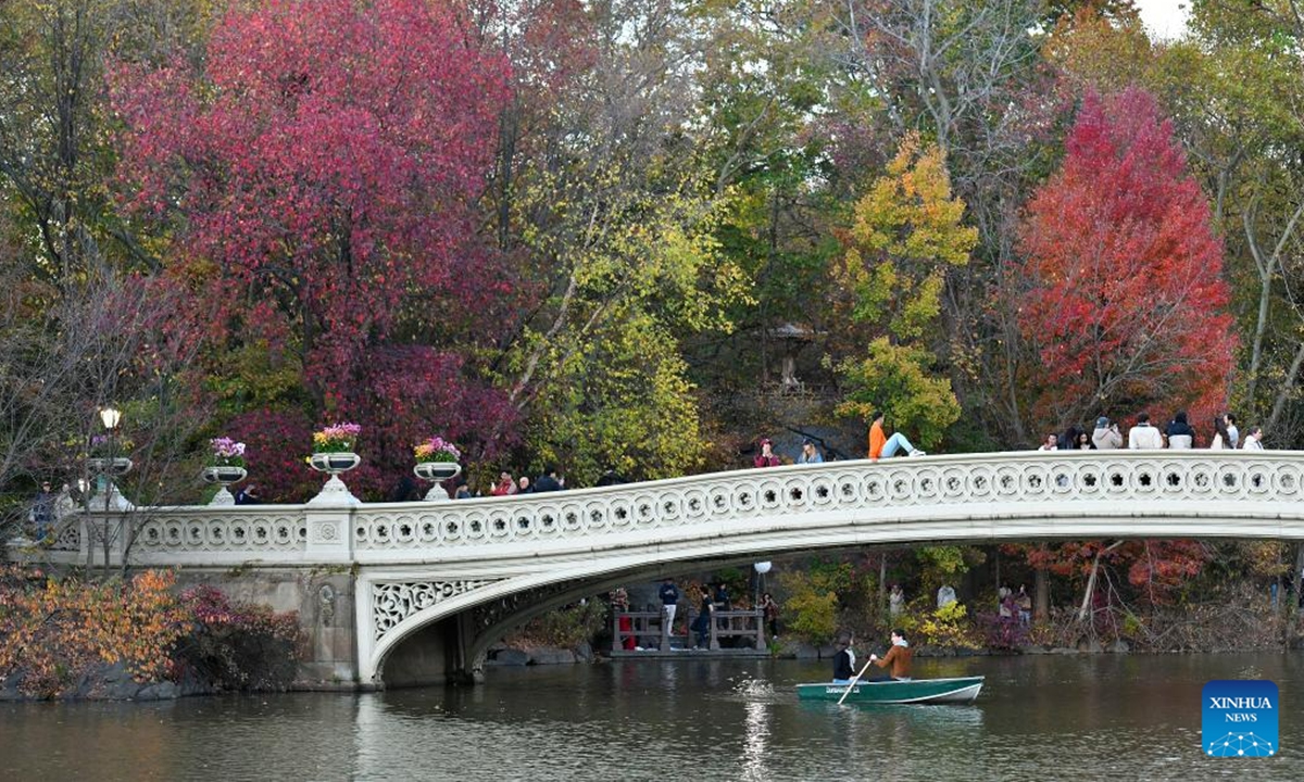 People visit the Bow Bridge with fall foliage as its backdrop at Central Park in New York, the United States, on Nov. 2, 2024. (Photo: Xinhua)