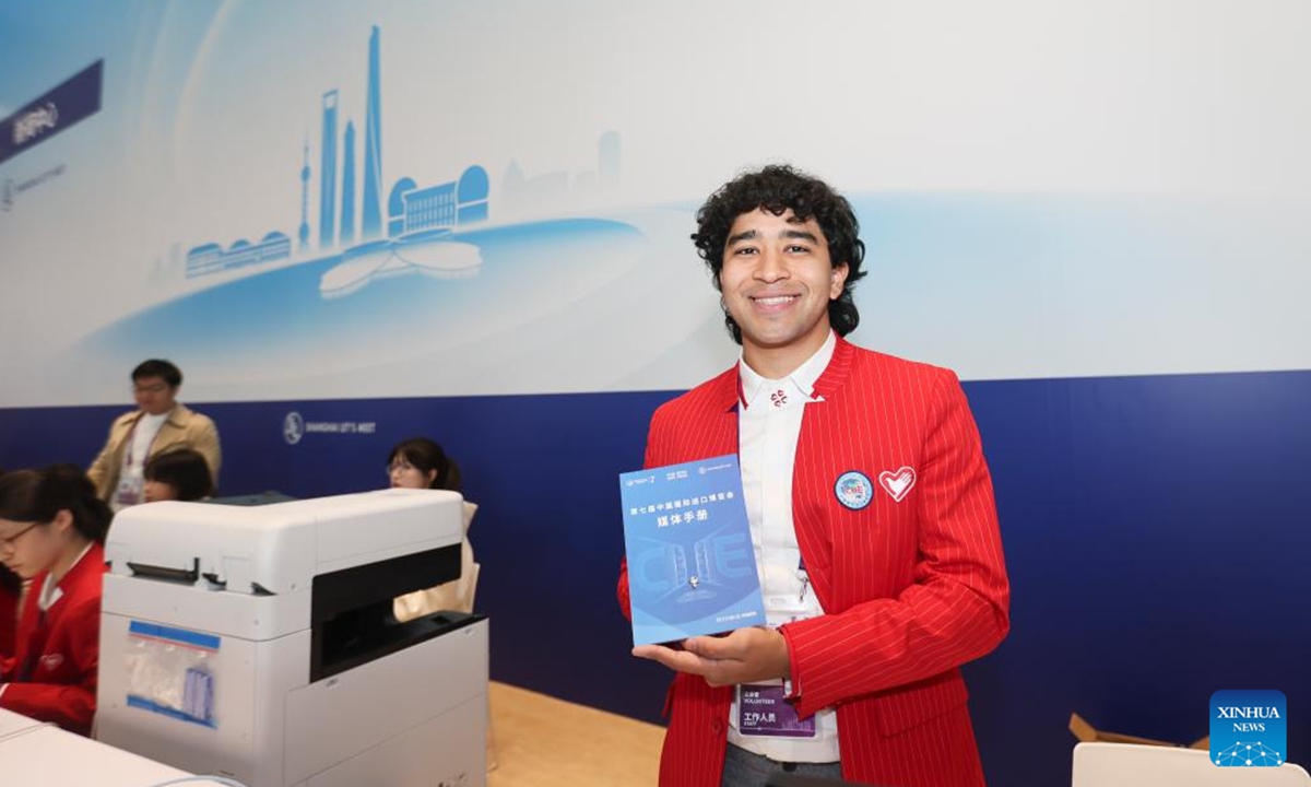 A Panamanian student of Tongji University who serves as a volunteer displays a media handbook at the media center for the 7th China International Import Expo (CIIE) at the National Exhibition and Convention Center (Shanghai) in Shanghai, east China, Nov. 3, 2024. The media center of the 7th CIIE opened on Sunday to provide services for journalists. (Photo: Xinhua)