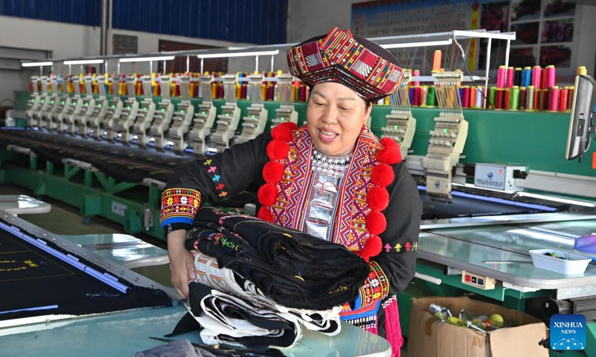 Pan Haiyan carries cloth in her embroidery workshop in Tianlin County, Baise City, south China's Guangxi Zhuang Autonomous Region, Oct. 31, 2024. Boasts a long history, Tianlin Yao ethnic embroidery skill is known for exquisite patterns, with the themes of creation mainly based on life of the Yao people. (Photo: Xinhua)