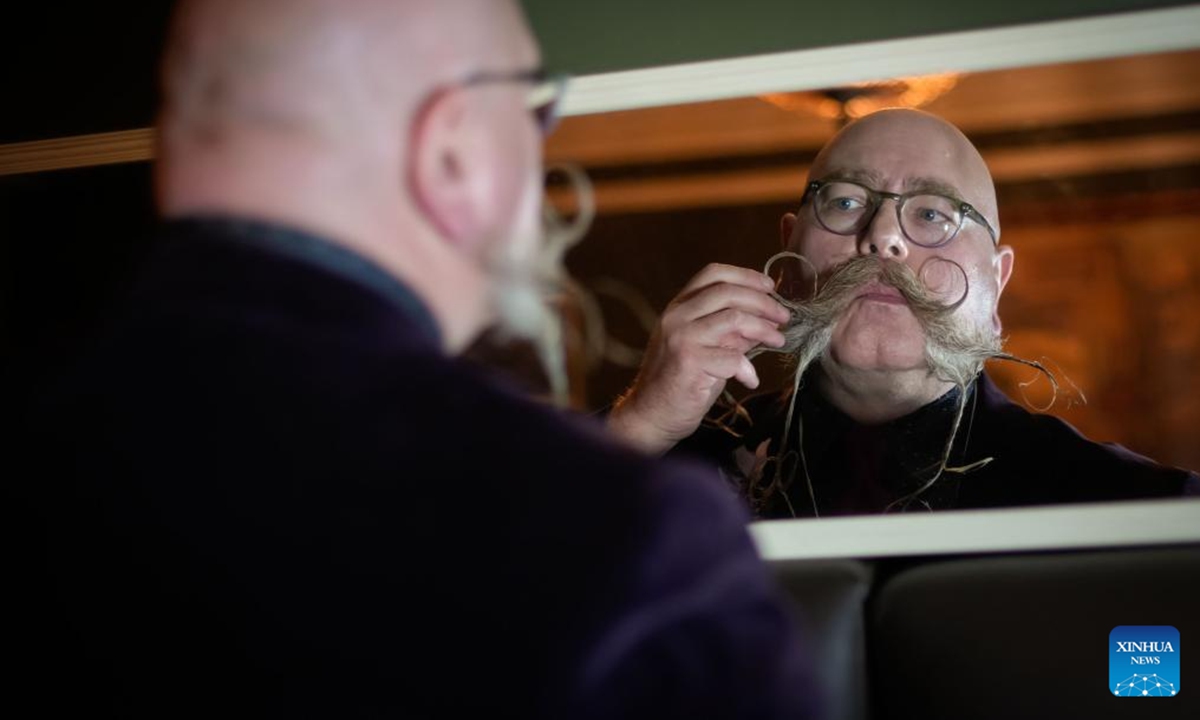 A contestant checks his moustache in a mirror during the annual Facial Hair Competition in Vancouver, British Columbia, Canada, Nov. 2, 2024. (Photo: Xinhua)