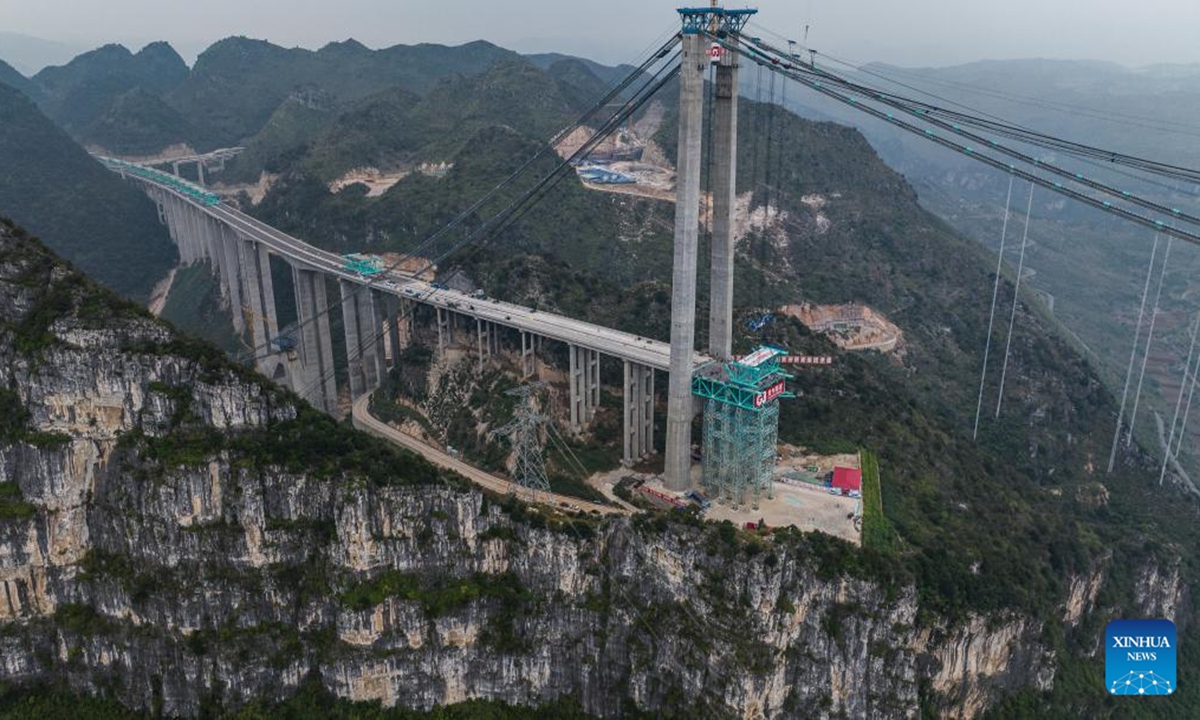 An aerial drone photo taken on Nov. 4, 2024 shows the Huajiang Grand Canyon Bridge's first steel truss girder, weighing about 215 tonnes, being hoisted to its designated position for installation in southwest China's Guizhou Province.(Photo: Xinhua)