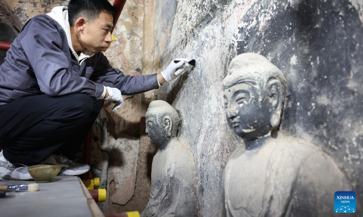 Yang Zhiqiang, a cultural relics restorer of Maiji Mountain Grottoes art institute, carries out protection and restoration work at a cave of the Maiji Mountain Grottoes in Maiji District of Tianshui City, northwest China's Gansu Province on Nov. 2, 2024. The Maiji Mountain Grottoes is one of the four most famous grottoes in China.  (Photo: Xinhua)