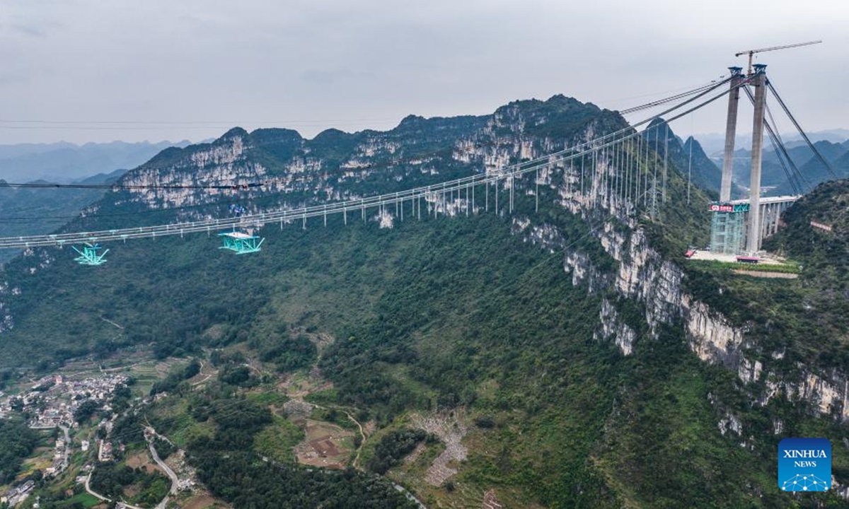 An aerial drone photo taken on Nov. 4, 2024 shows the Huajiang Grand Canyon Bridge's first steel truss girder, weighing about 215 tonnes, being hoisted to its designated position for installation in southwest China's Guizhou Province.(Photo: Xinhua)