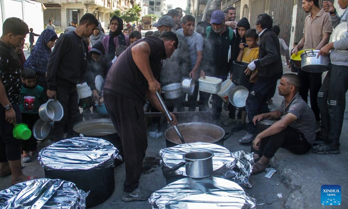 People receive food relief in Gaza City, on Nov. 4, 2024. The entire Palestinian population in North Gaza is at imminent risk of dying from disease, famine and violence, a joint statement signed by the heads of 15 UN agencies, including the World Health Organization, the UN Children's Fund, International Organization for Migration, the World Food Programme, and aid groups, said. (Photo: Xinhua)