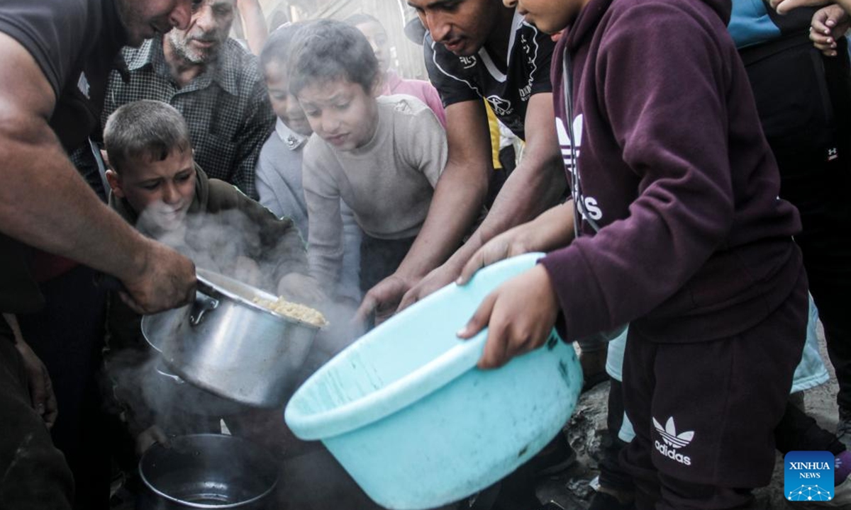 People receive food relief in Gaza City, on Nov. 4, 2024. The entire Palestinian population in North Gaza is at imminent risk of dying from disease, famine and violence, a joint statement signed by the heads of 15 UN agencies, including the World Health Organization, the UN Children's Fund, International Organization for Migration, the World Food Programme, and aid groups, said. (Photo: Xinhua)