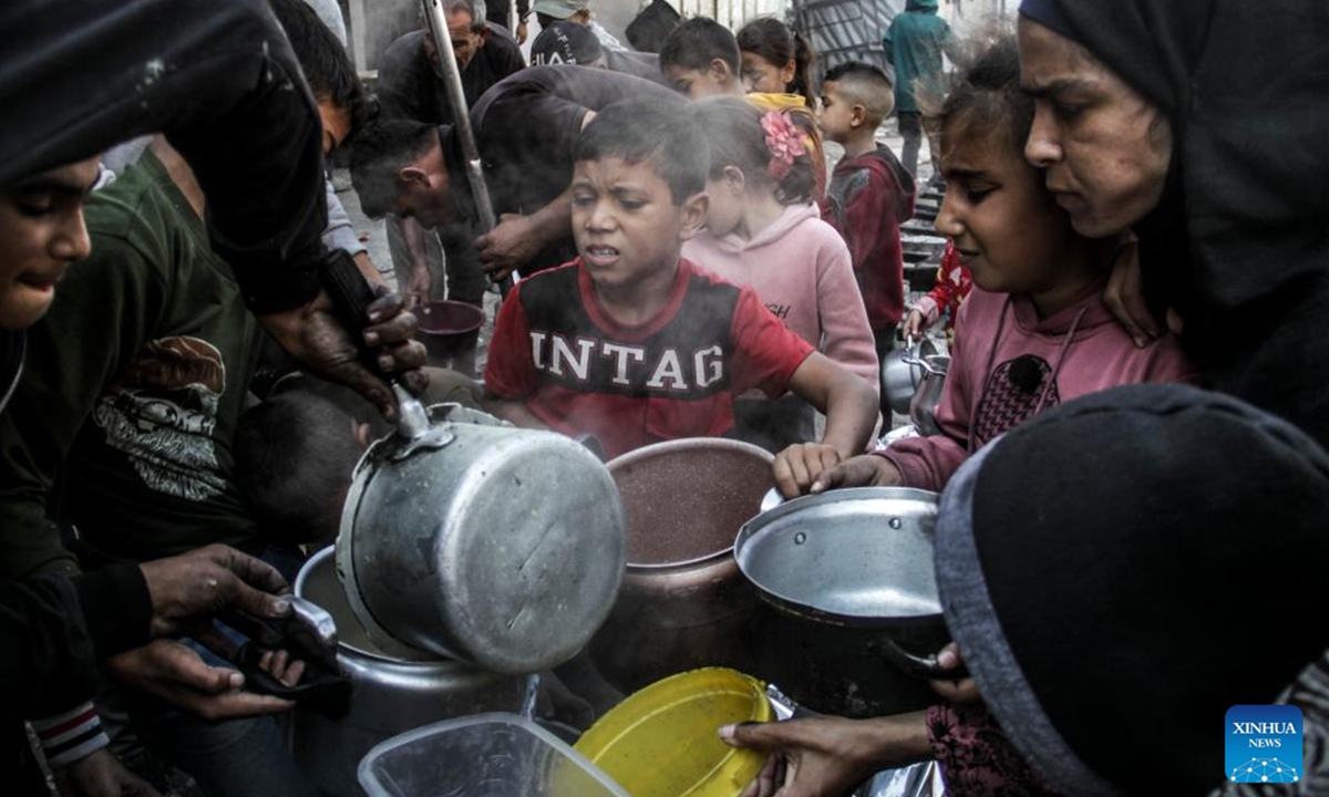 People receive food relief in Gaza City, on Nov. 4, 2024. The entire Palestinian population in North Gaza is at imminent risk of dying from disease, famine and violence, a joint statement signed by the heads of 15 UN agencies, including the World Health Organization, the UN Children's Fund, International Organization for Migration, the World Food Programme, and aid groups, said. (Photo: Xinhua)