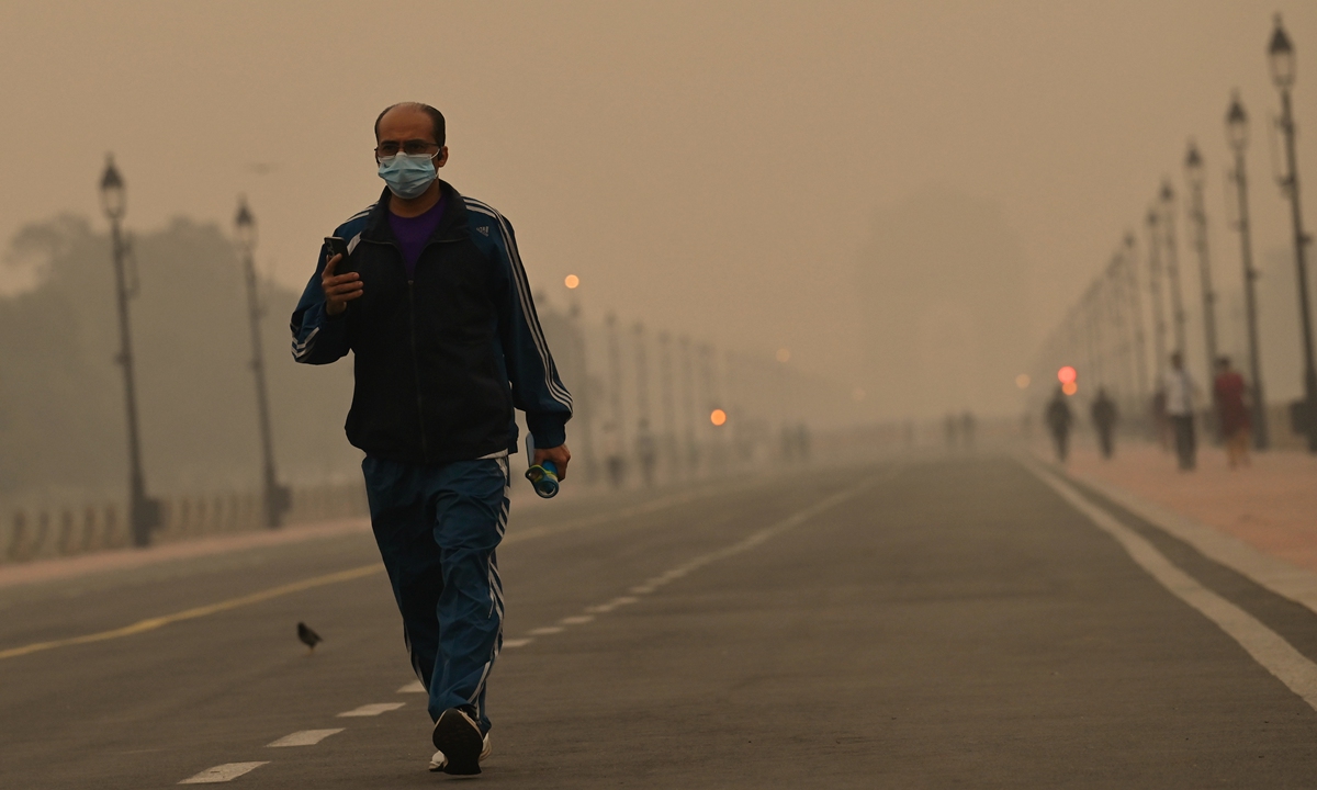 A masked man walks through smog during the early hours of the morning at Kartavya Path, on November 4, 2024 in New Delhi, India. The Indian capital has been shrouded in the annual thick toxic smog that marks the unwelcome beginning of 