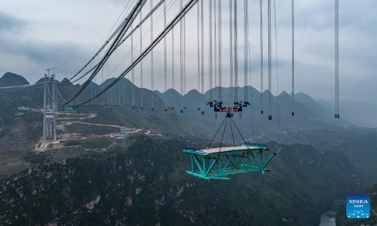 An aerial drone photo taken on Nov. 4, 2024 shows the Huajiang Grand Canyon Bridge's first steel truss girder, weighing about 215 tonnes, being hoisted to its designated position for installation in southwest China's Guizhou Province.(Photo: Xinhua)