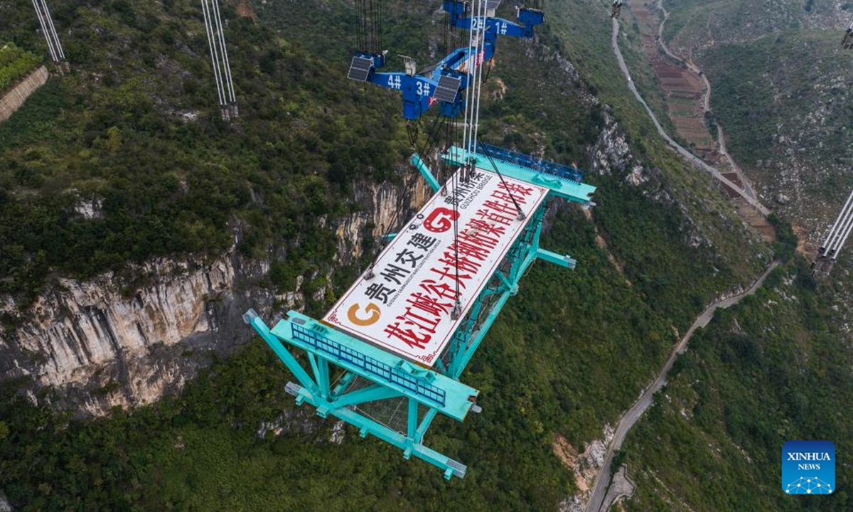 An aerial drone photo taken on Nov. 4, 2024 shows the Huajiang Grand Canyon Bridge's first steel truss girder, weighing about 215 tonnes, being hoisted to its designated position for installation in southwest China's Guizhou Province.(Photo: Xinhua)