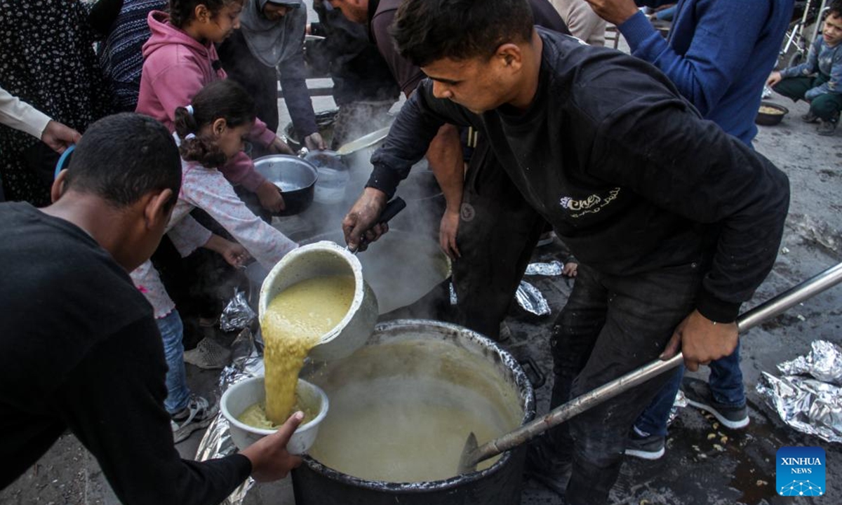 People receive food relief in Gaza City, on Nov. 4, 2024. The entire Palestinian population in North Gaza is at imminent risk of dying from disease, famine and violence, a joint statement signed by the heads of 15 UN agencies, including the World Health Organization, the UN Children's Fund, International Organization for Migration, the World Food Programme, and aid groups, said. (Photo: Xinhua)