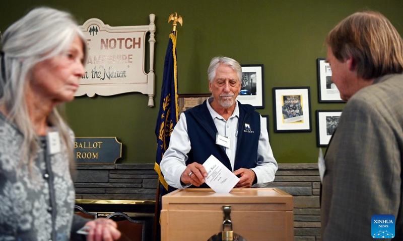 A ballot clerk helps a voter (R) cast his ballot for the U.S. presidential election in Dixville Notch, New Hampshire, the United States, Nov. 5, 2024. Voters in Dixville Notch, New Hampshire, went to the polls early Tuesday morning, marking the official start of Election Day voting for the 2024 U.S. presidential election. (Photo: Xinhua)