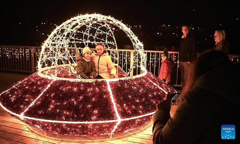 People pose for photos with a light installation during a space-themed light exhibition in Prague, the Czech Republic, on Nov. 9, 2024. (Photo by Dana Kesnerova/Xinhua)