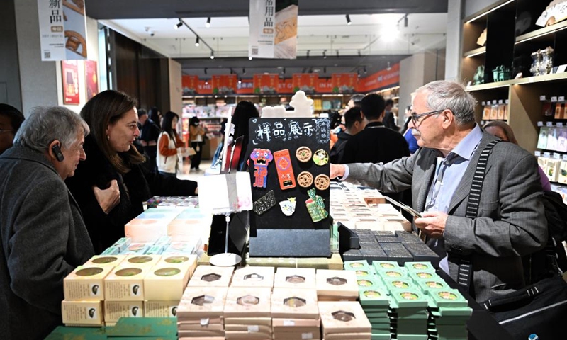 Guests select creative cultural products at the Henan Museum in Zhengzhou, central China's Henan Province, Nov. 4, 2024. Over 40 foreign participants of the inaugural World Conference on Classics visited Henan to explore the openness and inclusiveness of Chinese civilization from Nov. 3 to 5. (Photo: Xinhua)