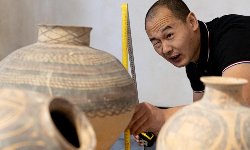 A Chinese staff member takes measurements of a batch of 56 lost Chinese cultural relics to be returned from Italy before packing them up in Rome, Italy, Oct. 28, 2024. (Xinhua/Li Jing)