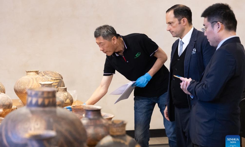 Chinese and Italian staff members check and verify a batch of 56 lost Chinese cultural relics to be returned from Italy before packing them up in Rome, Italy, Oct. 28, 2024. (Xinhua/Li Jing)