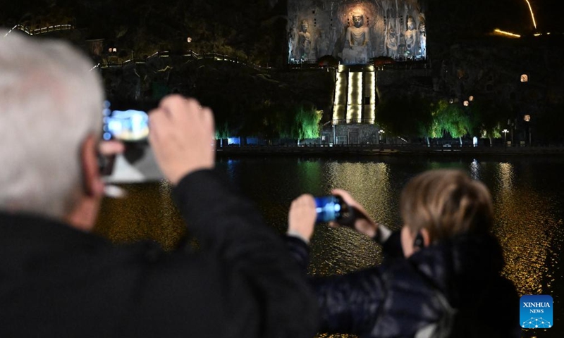 Guests take photos at Longmen Grottoes in Luoyang, central China's Henan Province, Nov. 4, 2024. Over 40 foreign participants of the inaugural World Conference on Classics visited Henan to explore the openness and inclusiveness of Chinese civilization from Nov. 3 to 5. (Photo: Xinhua)