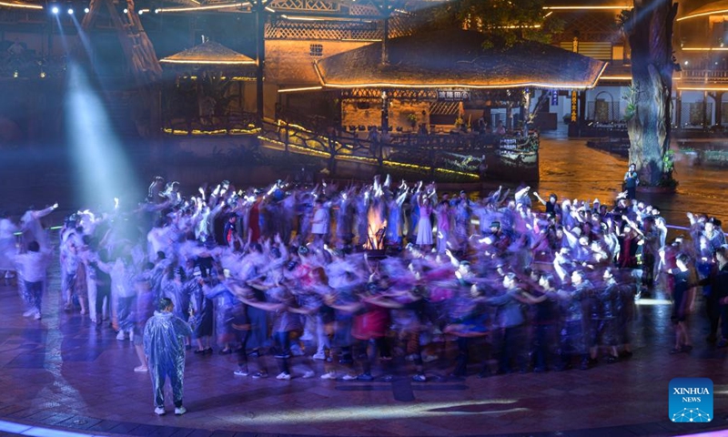 Tourists join in a group dance at Binglanggu tourism area in Baoting Li and Miao Autonomous County, south China's Hainan Province, Nov. 4, 2024. Binglanggu tourism area nestled in a tropical rainforest has being dedicated for years to promoting the culture of Li, an ethnic minority group native to this island province.  (Photo: Xinhua)