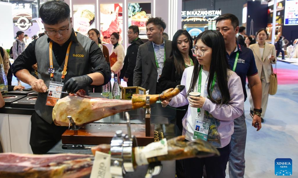 Visitors wait to taste Spanish ham during the seventh China International Import Expo (CIIE) in east China's Shanghai, Nov. 6, 2024. Food and agricultural products on display at the ongoing CIIE attracted visitors' attention. (Photo: Xinhua)