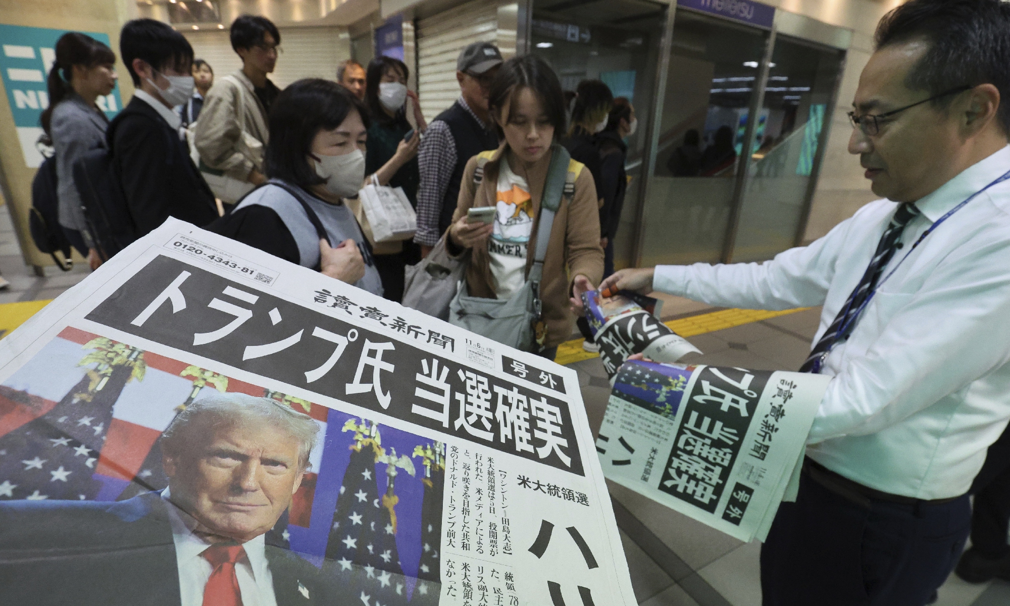 People receive on the street an extra edition of the Yomiuri Shimbun announcing Donald Trump's victory in the US presidential election, in Nagoya City, Japan on November 6, 2024. Photo: VCG