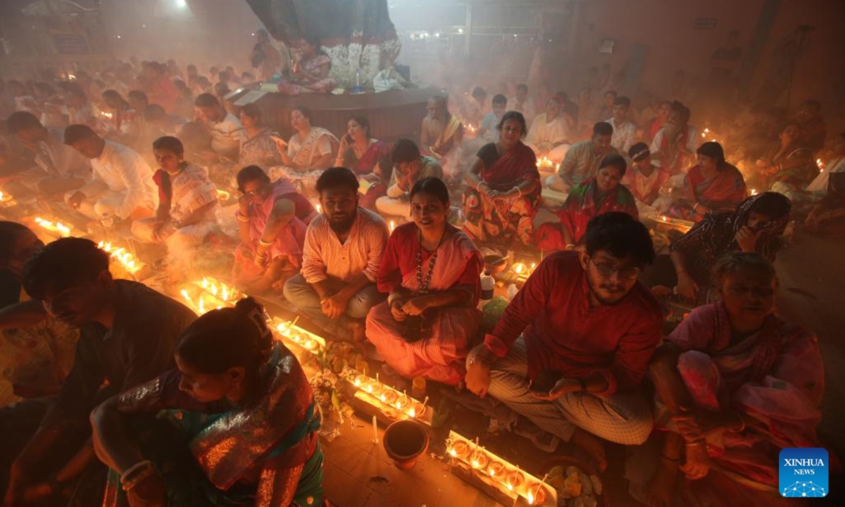 Devotees sit for prayer with burning incense and light oil lamps during the Rakher Upobash, a religious fasting festival, at a temple in Narayanganj, Bangladesh, on Nov. 5, 2024. (Photo: Xinhua)