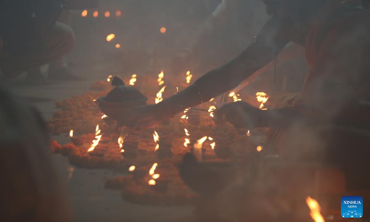 A devotee lights an oil lamp during the Rakher Upobash, a religious fasting festival, at a temple in Narayanganj, Bangladesh, on Nov. 5, 2024. (Photo: Xinhua)