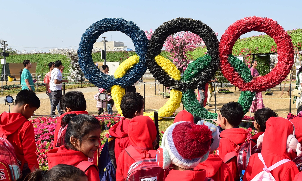 School children watch a floral display of the Olympic rings at the Vibrant Ahmedabad Flower Show 2024 in Ahmedabad, India on January 6, 2024.  Photo: VCG