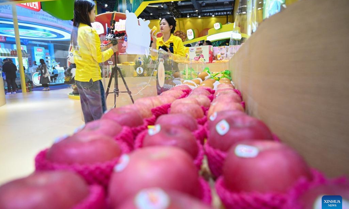 Exhibitors promote fruits via live-streaming during the seventh China International Import Expo (CIIE) in east China's Shanghai, Nov. 6, 2024. Food and agricultural products on display at the ongoing CIIE attracted visitors' attention. (Photo: Xinhua)