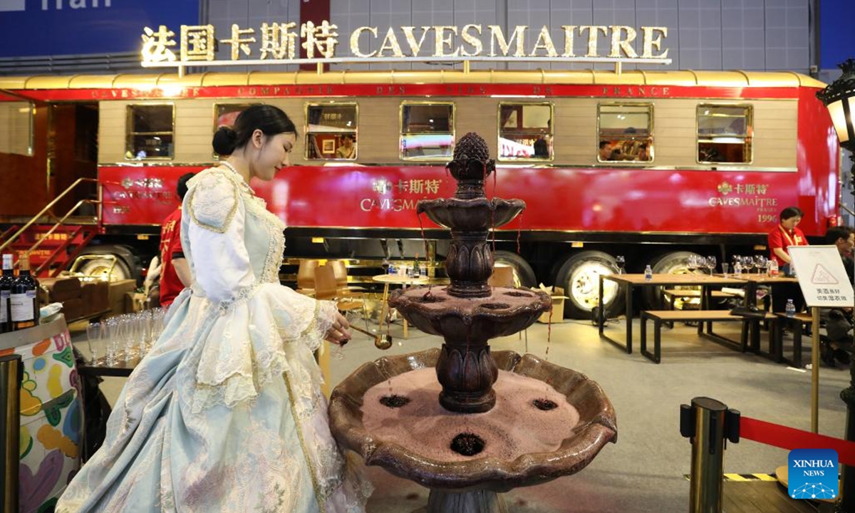 A staff member prepares wine for visitors during the seventh China International Import Expo (CIIE) in east China's Shanghai, Nov. 6, 2024. Food and agricultural products on display at the ongoing CIIE attracted visitors' attention. (Photo: Xinhua)