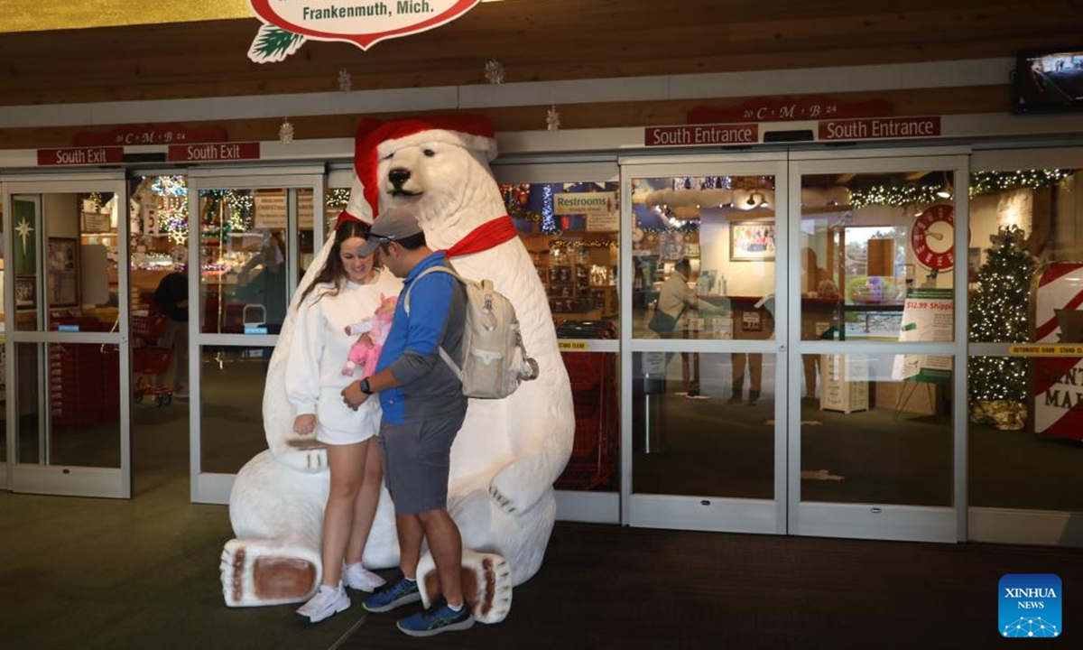 People pose for photos in front of Bronner's CHRISTmas Wonderland in Frankenmuth, Michigan, the United States, on Oct. 30, 2024. Bronner's CHRISTmas Wonderland in Frankenmuth is striving to recover from the COVID-19 pandemic while shoppers are returning and sales climbing up, according to staff members and customers interviewed by Xinhua reporters there at the end of October.  (Photo: Xinhua)