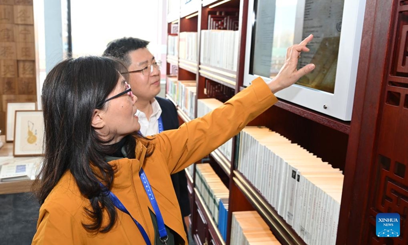 A staff member shows an interactive screen with classic books during an exhibition on classical studies achievements in Beijing, capital of China, on Nov. 7, 2024. The exhibition opened here on Thursday, as one of the auxiliary activities of the World Conference of Classics scheduled from Nov. 6 to 8 in Beijing. (Photo: Xinhua)