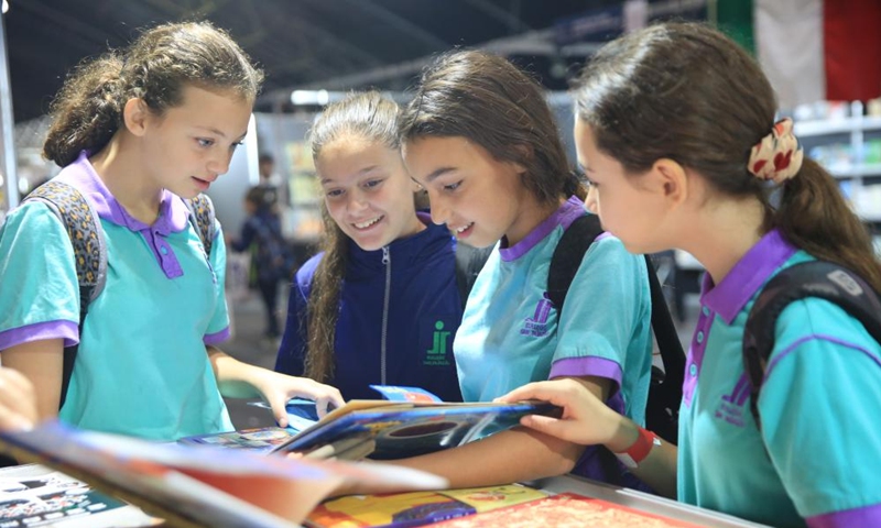 Students read a book at the Chinese exhibition booth during the Malta Book Festival in Ta' Qali, Attard, Malta, on Nov. 8, 2024. A delegation of Chinese publishers, alongside the China Cultural Center in Malta, showcased a variety of Chinese publications at the 45th Malta Book Festival, which runs from Nov. 6 to Nov. 10 in Attard, central Malta. (Photo: Xinhua)