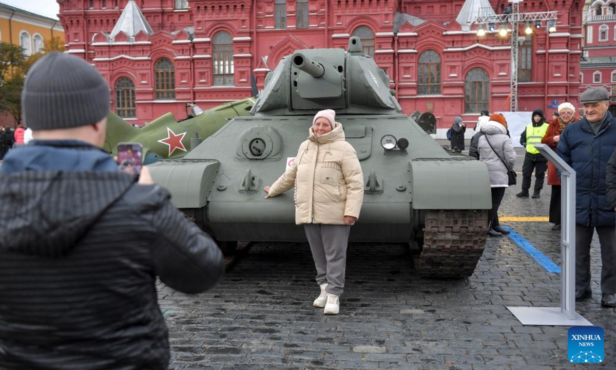 A woman poses for photos at an outdoor exhibition commemorating the military parade in 1941 at Red Square in Moscow, Russia, Nov. 7, 2024.   (Photo: Xinhua)